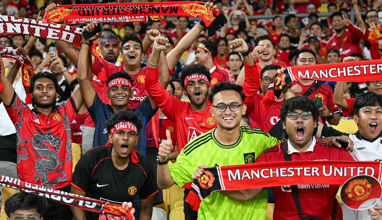 Para fans Manchester United memberikan dukungan kepada timnya dalam laga persahabatan melawan ASEAN All-Stars yang berlangsung di Stadion Bukit Jalil, Malaysia, pada hari Rabu (28/5/2025) malam waktu setempat. (AFP/Mohd Rasfan)