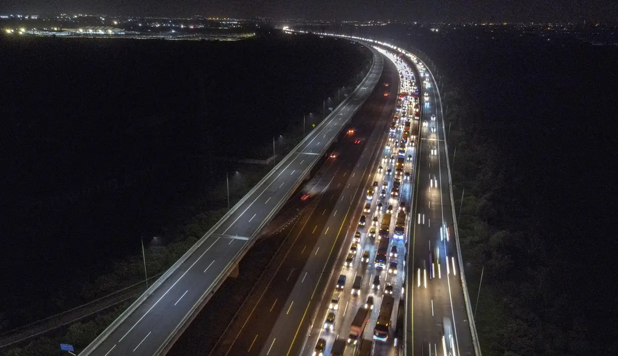 <p>Foto udara ini menunjukkan kendaraanroda empat tersendat saat melintasi&nbsp; Jalan Tol Jakarta - Cikampek di Karawang, Jawa Barat pada 28 April 2022. Lalu lintas di Jalan Tol Jakarta-Cikampek mengalami kemacetan panjang memasuki puncak arus mudik Lebaran 2022. (BAY ISMOYO / AFP)</p>