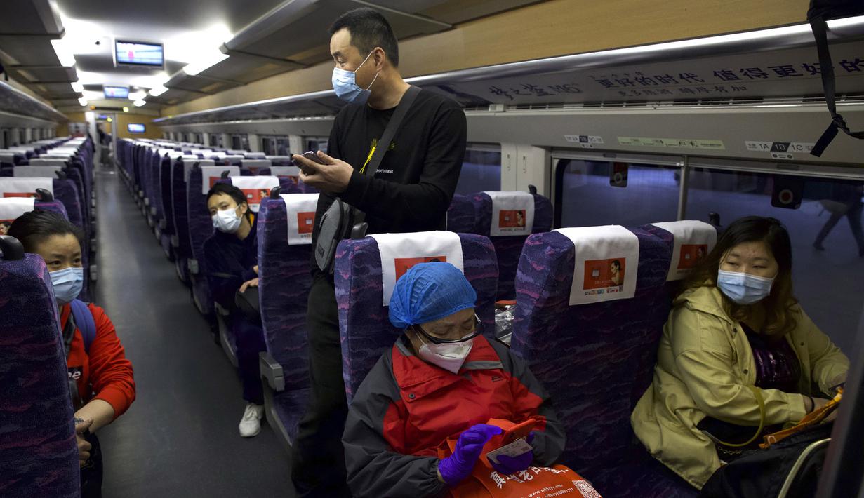 Penumpang mengenakan masker saat menaiki kereta pertama yang meninggalkan Stasiun Hankou, Wuhan, Provinsi Hubei, China, Rabu (8/4/2020). Setelah 11 minggu lockdown, layanan kereta di kota yang menjadi titik awal pandemi virus corona COVID-19 ini kembali beroperasi. (AP Photo/Ng Han Guan)