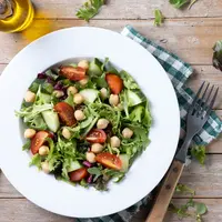 Menu chickpea salad dengan lemon dressing tidak hanya menyegarkan, tetapi juga memiliki kandungan yang kaya akan protein nabati, lemak sehat, dan antioksidan. (Foto/dok: Freepik/chandlervid85)