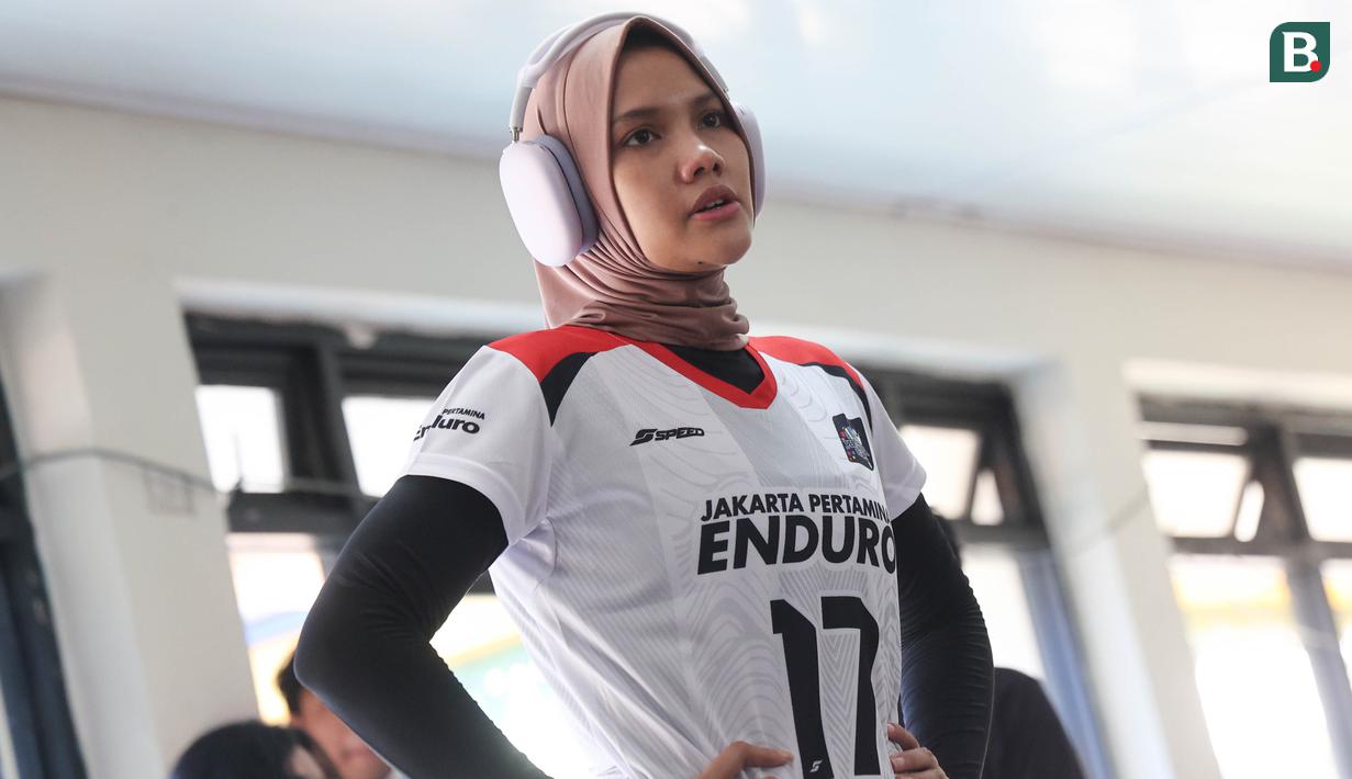 Nandita Ayu Salsabila mencoba santai dengan mendengarkan musik pada sesi latihan Jakarta Pertamina Enduro yang bertempat di GOR Bulungan, Jakarta Selatan, Selasa (31/12/2024). (Bola.com/Abdul Aziz)
