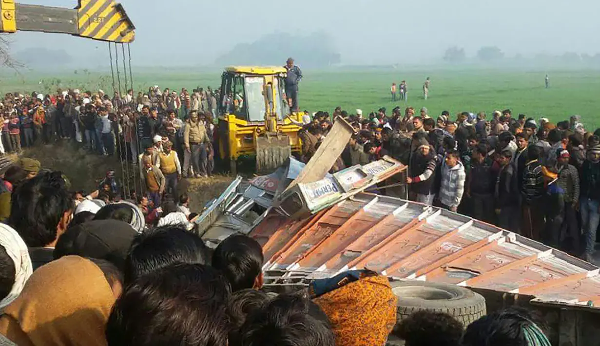 Sejumlah orang berkumpul di lokasi kecelakaan antara bus sekolah dan truk di Etah, negara bagian Uttar Pradesh, India, Kamis (19/1). Dalam tragedi tersebut sedikitnya 15 anak dan pengemudi bus tewas serta puluhan lainnya terluka. (AFP PHOTO/STR)