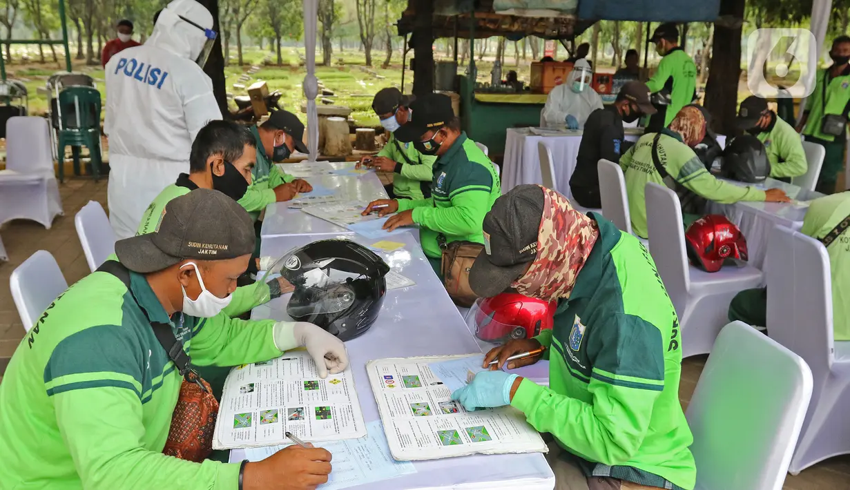 Petugas penggali makam mengikuti ujian teori saat  pelayanan penerbitan SIM baru di TPU Pondok Ranggon, Jakarta, Kamis (2/7/2020). Direktorat Lalu Lintas Polda Metro Jaya memberikan pelayanan penerbitan SIM baru gratis bagi penggali makam yang menangani korban Covid-19.(Liputan6.com/Herman Zakharia)