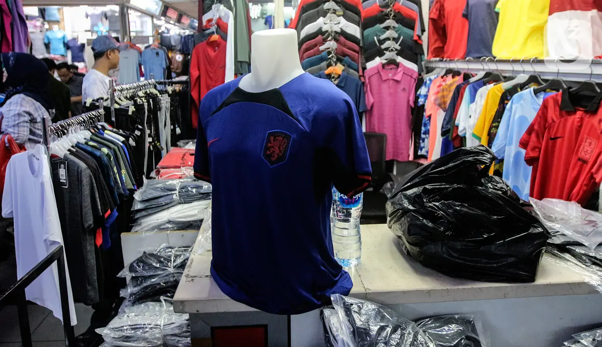 Jersey salah satu timnas sepak bola peserta Piala Dunia Qatar 2022 dipajang di salah satu kios, Blok B Pasar Tanah Abang, Jakarta, Kamis (24/11/2022). Menurut pedagang, permintaan jersey timnas meningkat dikarenakan Piala Dunia Qatar 2022 yang dimulai sejak 20 November 2022. (Liputan6.com/Johan Tallo)