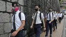 Para siswa sekolah mengenakan topeng dan helm berjalan di luar St. Paul's College selama protes di Hong Kong, Selasa (3/9/2019). Puluhan ribu siswa di Hong Kong memprotes terhadap gerakan anti-pemerintah. (AP Photo/Kin Cheung)