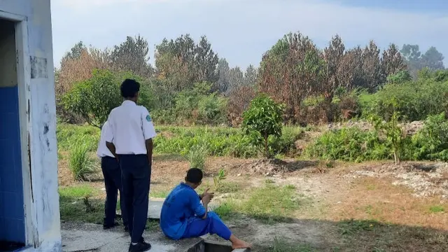 Pelajar SMP 8 Tambang melihat kebakaran lahan yang sangat dekat dengan sekolahnya.