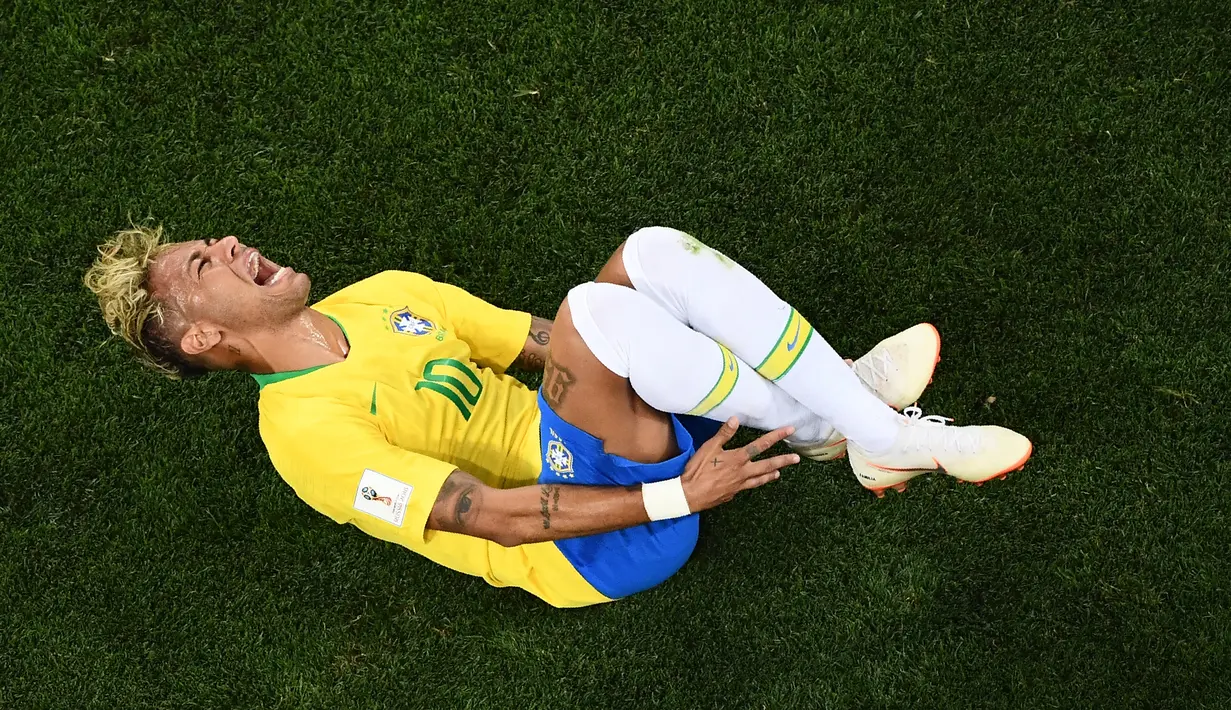 Pemain Brasil, Neymar mengerang kesakitan setelah mendapat sleding dari Valon Behrami saat Brasil melawan Swiss pada penyisihan Grup E Piala Dunia 2018 di Rostov Arena, Rostov-On-Don, Rusia, Minggu (17/6). (Permata Samad/AFP)