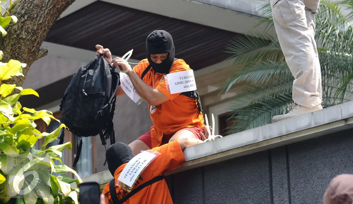 Dua dari lima tersangka kasus perampokan disertai penyanderaan melakukan adegan rekonstruksi kejadian di Jalan Metro Hijau IX, Jakarta, Selasa (13/9). 60 adegan reka ulang kejadian diperagakan tersangka. (Liputan6.com/Helmi Fithriansyah)
