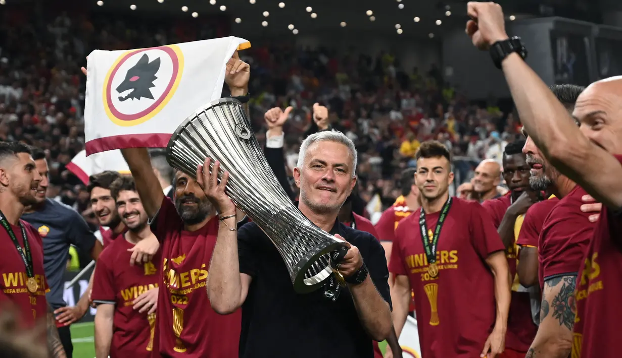 <p>Pelatih AS Roma Jose Mourinho memegang trofi setelah timnya memenangkan partai final Liga Konferensi Eropa UECL musim 2021-222 melawan Feyenoord di Arena Kombetare, Tirana, Albania, Kamis (26/5/2022) dini hari WIB. 'Serigala Ibu Kota' menang 1-0 lewat gol Nicolo Zaniolo dan adalah gelar pertama AS Roma sejak 14 tahun terakhir. (OZAN KOSE / AFP)</p>