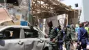 Petugas polisi mengecek sebuah mobil di lokasi serangan bom mobil di Distrik Hamarwayne, Mogadishu, Ibu Kota Somalia (4/2). Setidaknya sembilan orang tewas dan beberapa lainnya cedera akibat serangan bom mobil tersebut. (AFP Photo/Abdirazak Hussein Farah)