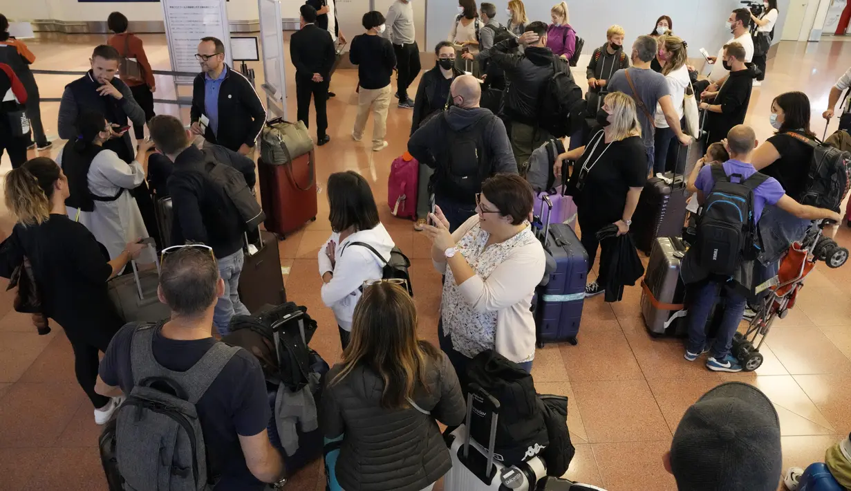 <p>Wisatawan asing berkumpul setibanya di Bandara Internasional Haneda, Tokyo, Selasa (11/10/2022). Mulai 11 Oktober, Jepang memulihkan pariwisata individu dan perjalanan bebas visa kepada orang-orang dari negara tertentu selama mereka divaksinasi. (AP Photo/Eugene Hoshiko)</p>