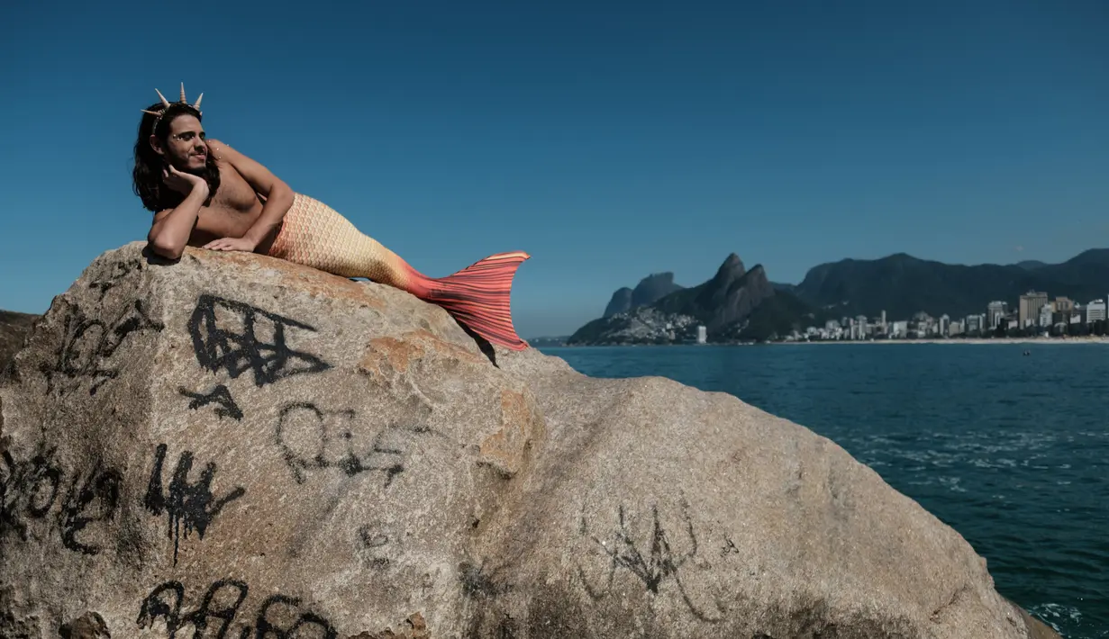 Seorang pria bernama Davi de Oliveira Moreira berjemur di Pantai Ipanema di Rio de Janeiro, Brasil, Rabu (3/5). Davi menjadi salah satu bagian dari penggila putri duyung yang sedang tumbuh di Brasil. ( AFP FOTO / YASUYOSHI CHIBA)