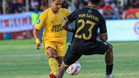 Winger Semen Padang, Irkham Mila (Kuning) mencoba menghindari hadangan dari pemain Maluku United, Yance Sayuri (23). (Bola.com/Nandang Permana)