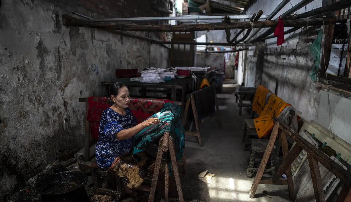 Seorang pekerja mencanting batik di pabrik "batik" kain tradisional Indonesia di Sidoarjo, Jawa Timur (12/11/2019). UNESCO menetapkan batik sebagai karya agung lisan dan warisan budaya takbenda kemanusiaan. (AFP Photo/Juni Kriswanto)