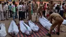 Petugas kepolisian mengatur mayat korban di luar rumah sakit di Etah, India, Jumat (5/5). Truk yang membawa sejumlah orang usai kembali dari upacara pernikahan mengalami kecelakaan jatuh ke sungai. (AFP/STR)