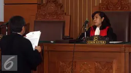 Kuasa hukum RJ Lino, Maqdir Ismail (kiri) menyerahkan surat gugatan praperadilan kepada hakim tunggal Udjiati (kanan) saat sidang praperadilan mantan Direktur Utama Pelindo II RJ Lino di PN Jakarta Selatan, Senin (11/1/2016). (Liputan6.com/Yoppy Renato)