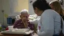 Ekspresi seorang pasien saat mendengarkan musik dari Musica Para el Alma yang tampil di Rumah Sakit Alvarez di Buenos Aires, Argentina (12/6). (AFP Photo/Eitan Abramovich)