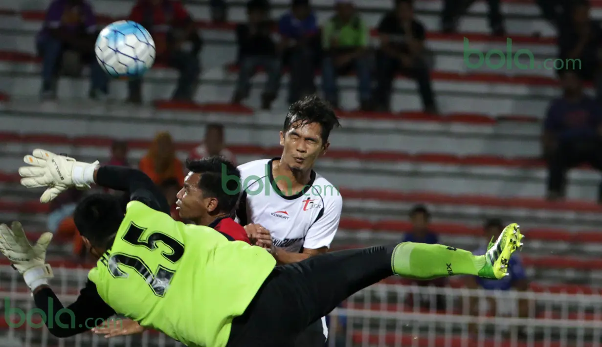 Kiper ATM FA berusaha menghadang sundulan pemain T-Team Malaysia pada laga play-off Malaysia Super League 2016. (Bola.com/Nicklas Hanoatubun)