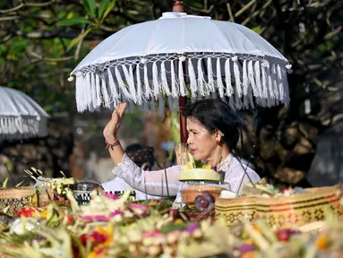 Seorang perempuan umat Hindu berdoa saat mengikuti sembahyang perayaan hari raya Galungan di Pura Jagat Natha di Denpasar, Bali, Rabu (8/6/2022). Hari Raya Galungan merupakan hari merayakan kemenangan kebaikan (Dharma) melawan kejahatan (Adharma). (SONNY TUMBELAKA / AFP)