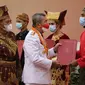 Gubernur Riau Syamsuar bersama Kepala Kanwil Kemenkumham Riau Mhd Jahari Sitepu memberikan surat remisi kepada narapidana. (Liputan6.com/M Syukur)