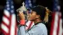 Petenis Jepang, Naomi Osaka mencium trofi turnamen AS Terbuka setelah mengalahkan Serena Williams pada partai final di New York, Sabtu (8/9). Osaka menjadi kampiun AS Terbuka setelah mengalahkan Serena Williams, 6-2, 6-4. (JULIAN FINNEY/GETTY IMAGES/AFP)