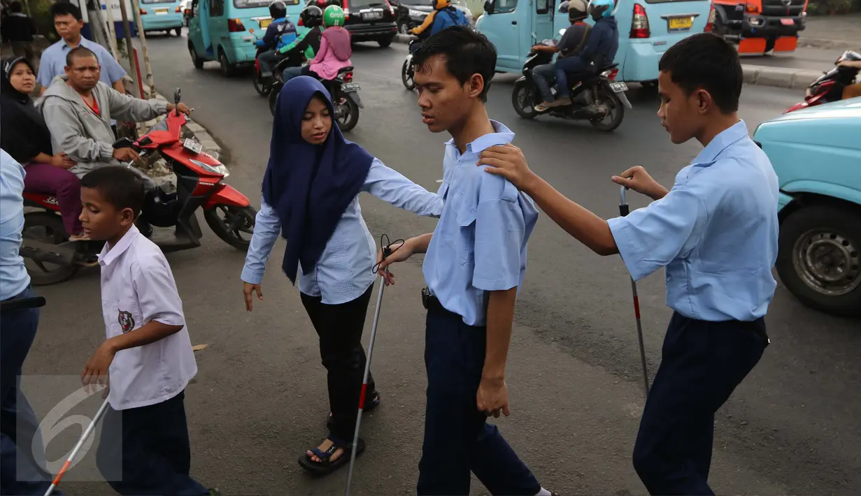 Guru membimbing siswa PSBN Cahaya Bathin penyandang tunanetra mengikuti praktik orientasi mobilitas di Cawang, Jakarta, Selasa (11/4). Praktik itu untuk melatih kemandirian siswa menghadapi situasi apapun dalam kesehariannya. (Liputan6.com/Gempur M Surya)