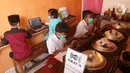 Sejumlah siswa sekolah dasar belajar dengan menggunakan wifi gratis yang disediakan oleh warkop Rizki, di Pondok Aren, Tangerang Selatan, Rabu (29/7/2020). Wifi gratis disediakan untuk membantu anak anak sekitar yang tidak memiliki jaringan internet dan smartphone. (Liputan6.com/Angga Yuniar)