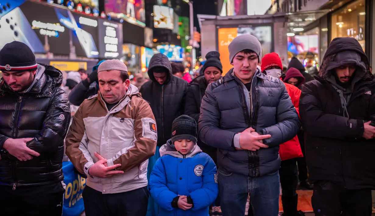 Salat sunah malam yang dilaksanakan khusus pada bulan Ramadan itu terasa berbeda karena berlatar papan reklame iklan LED terang yang menerangi landmark kota tersebut. (Adam GRAY/AFP)
