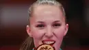 Atlet Karate putri Kazakhstan Guzalia Gafurova mengigit medali emasi cabang karate perempuan 68kg Asian Games ke-18 di Jakarta, Indonesia, (27/8). (AP Photo / Tatan Syuflana)