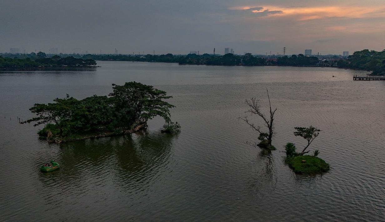 Permukaan air nan tenang menghadirkan pemandangan dengan daya tarik tersendiri. Tampak foto udara memperlihatkan area Situ Cipondoh di Kota Tangerang, Banten, nan tetap berfaedah sebagai area konservasi air sekaligus destinasi rekreasi warga, Rabu (14/4/2026). (merdeka.com/Arie Basuki)