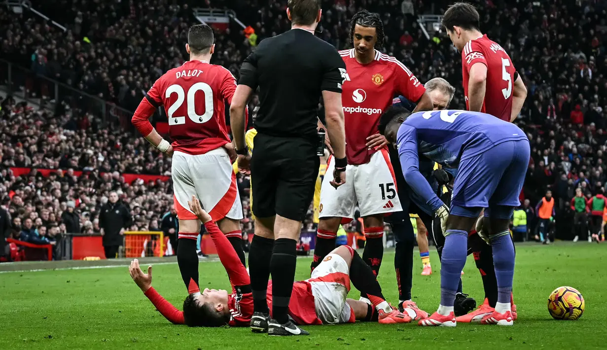 Pemain Manchester United, Lisandro Martinez mengeram kesakitan dalam laga lanjutan Liga Inggris 2024/2025 melawan Crystal Palace di Old Trafford, Manchester, Inggris, Minggu (02/02/2025). (AFP/Paul Ellis)