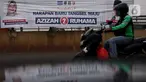 Pengedara melintas di depan alat peraga kampanye (APK) yang terpasang di kawasan Depok, dan Ciputat, Tangerang Selatan, Minggu (18/10/2020). KPU Kota Tangsel dan Depok membagikan sejumlah alat peraga kampanye kepada pasangan calon Pilkada 2020 serentak. (Liputan6.com/Johan Tallo)