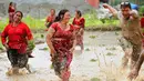 Warga Nepal bersuka ria sambil menari di lumpur pada Asar Pandra, atau hari menanam padi nasional di Lalitpur, 29 Juni 2018. Asar Pandra diadakan sebagai tanda dimulainya kembali aktivitas tanam padi di sawah saat musim hujan tiba. (AP Photo/Niranjan Shre