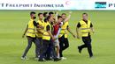 Petugas keamanan berhasil mengamankan seorang suporter yang masuk kedalam lapangan setelah laga FIFA Matchday antara Timnas Indonesia Vs Timnas Argentina di Stadion Utama Gelora Bung Karno (SUGBK), Senayan, Jakarta, Senin (19/06/2023). (Bola.com/M Iqbal Ichsan)