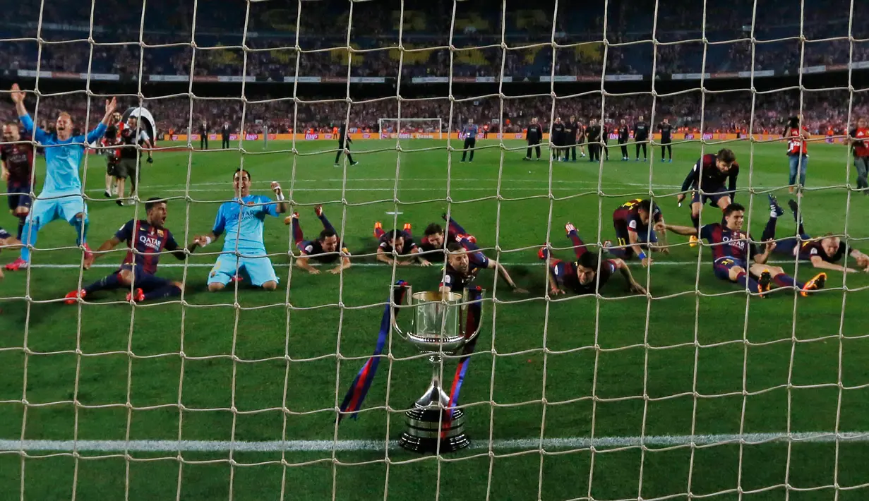 Para pemain Barcelona melakukan selebrasi dengan bertiduran di depan gawang dengan trofi Copa del Rey usai memenangkan final piala Raja di Nou Camp, Spanyol (31/5/2015). Barcelona berhasil menaklukkan Bilbao dengan skor akhir 3-1. (Reuters/Albert Gea)