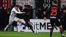 Penyerang AC Milan Rafael Leao (tengah) berebut bola dengan gelandang Empoli Nedim Bajrami pada pekan ke-29 Liga Italia di Stadion San Siro, Minggu (13/3/2022) dini hari WIB.  AC Milan menang tipis 1-0 atas tamunya, Empoli. (Miguel MEDINA / AFP)