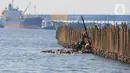 Sejumlah pekerja tampak memasang turap bambu yang menjadi penangkal abrasi di pesisir pantai kawasan Pelabuhan Marunda Center Terminal (MCT) Jurong Port JV, Tarumajaya, Bekasi, Jawa Barat (23/6/2023). (merdeka.com/Imam Buhori)
