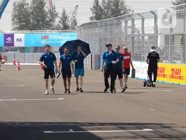 Sejumlah pembalap beserta kru tim peserta lomba balap mobil listrik Formula E melakukan persiapan dan driver track walk di lintasan sirkuit JIEC, Ancol, Pademangan, Jakarta Utara, Jumat (3/6/2022). Sesi driver track walk digunakan para pebalap dan kru untuk mengukur panjang lintasan serta adaptasi terhadap sirkuit.  (Liputan6.com/Herman Zakharia)