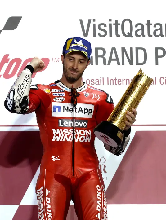 Pembalap Ducati, Andrea Dovizioso memegang piala setelah memenangkan seri pembuka MotoGP di Sirkuit Internasional Losail di Lusail, Qatar (10/3). (AFP Photo/Karim Jaafar)