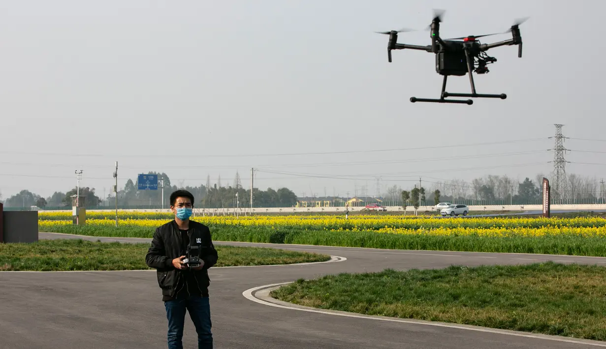 Seorang teknisi mengoperasikan sebuah drone pertanian untuk memotret beberapa gambar multispektral tanaman di sebuah lahan pertanian di Wilayah Dayi, Provinsi Sichuan, China, 24 Februari 2020. (Xinhua/Li Mengxin)