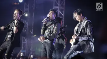 Aksi Fildan duet dengan Piyu (gitaris), Makki (bass), Posan (Drum), Dmitriev (Biola) dalam Grand Final Dangdut Academy 4 (D'Academy 4) di Studio 5 Indosiar, Jakarta, Jumat (19/5). (Liputan6.com/Faizal Fanani)