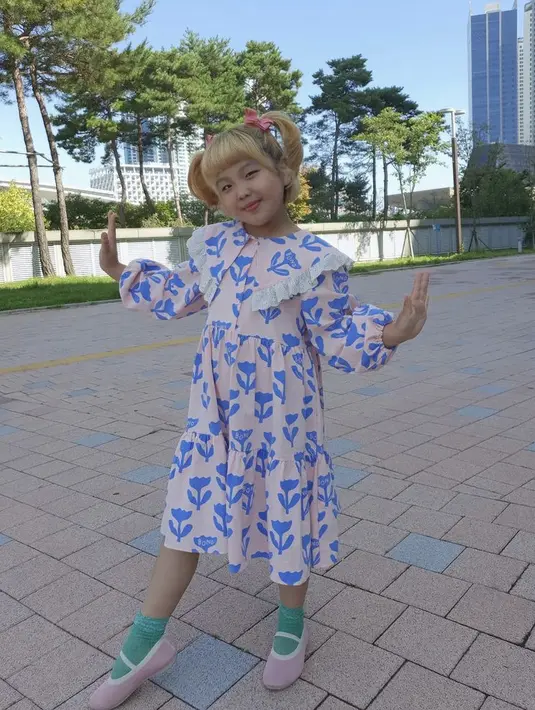 Ia juga tampil manis denhan dress motif flower denban setail krah collar san tangan ballon. Tampilnya semakin cute dengan kuncir duanya.  Instagramnya @lee_6038.