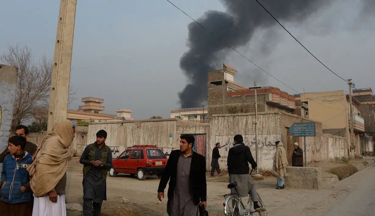 Warga sipil Afghanistan berhamburan saat terjadi serangan di dekat kantor amal Inggris Save the Children di Jalalabad, Afghanistan (24/1). (AFP Photo/Noorullah Shirzada)