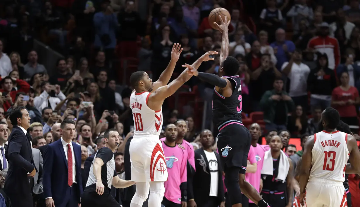 6. Aksi bintang Miami Heat, Dwayne Wade memblok lemparan dari Eric Gordon dalam lanjutan NBA di American Airlines Arena, Jumat (21/12/2018). Miami Heat menang 101-99 atas Houston Rockets. (AP)