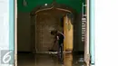 Warga memberiskan musholah di pemukiman penduduk Kampung Pulo, Jatinegara Barat yang ikut terendam banjir, Jakarta, Rabu (25/11/2015). Air aliran kali Ciliwung mulai memasuki rumah warga sekitar pukul 03.00 Wib dini hari tadi. (Liputan6.com/Yoppy Renato)