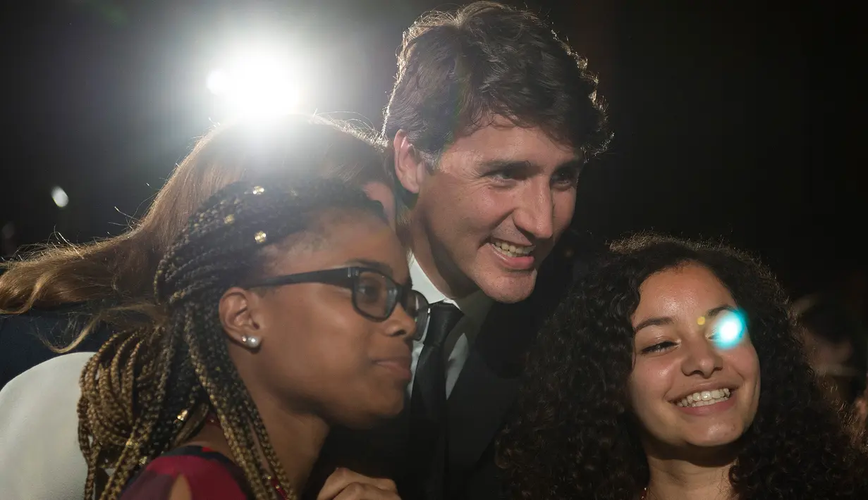 Sejumlah siswi SMA mengajak Perdana Menteri (PM) Kanada, Justin berswafoto ketika menghadiri acara Fortune Most Powerful Women Summit 2017 di Washington, Selasa (10/10). (AFP Photo / Andrew CABALLERO-REYNOLDS)