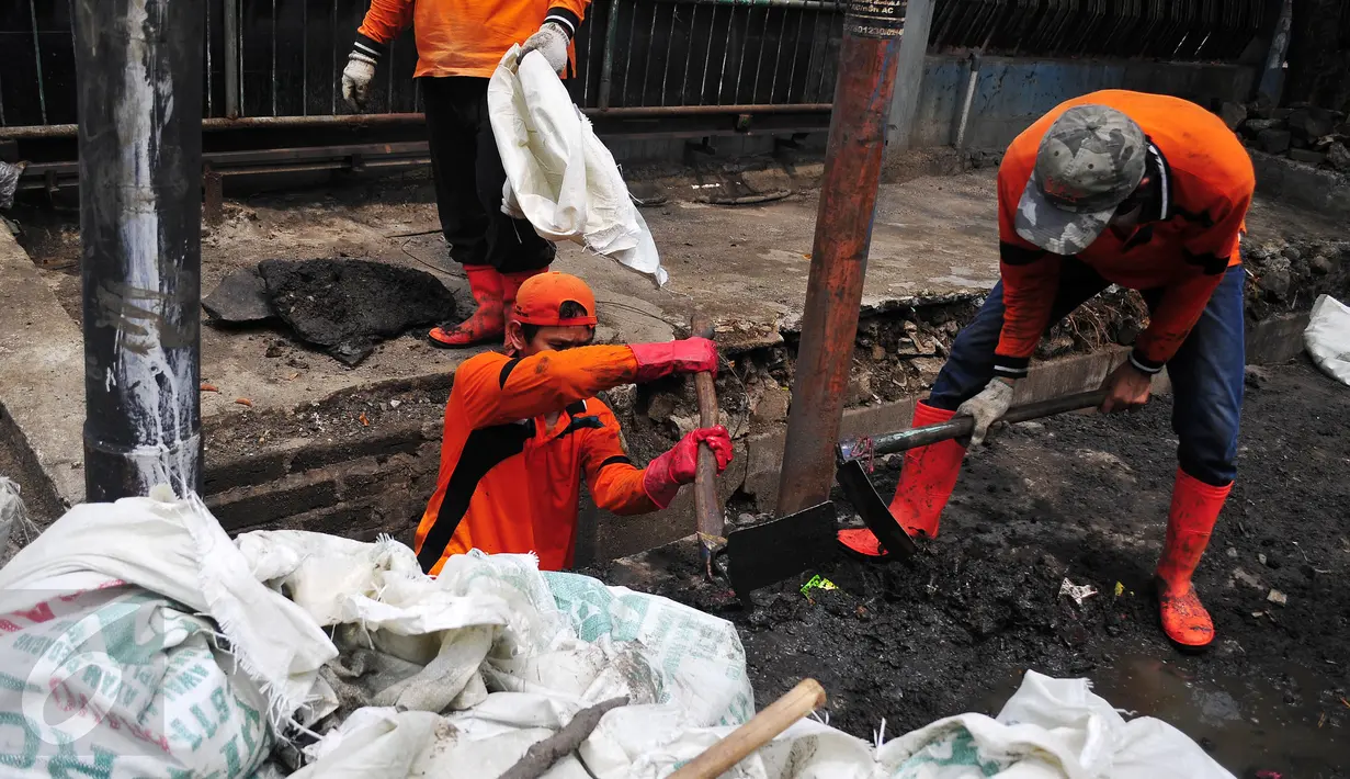Petugas melakukan pembersihan saluran air di pinggir jalan Ampera Raya, Jakarta, Selasa (3/11/2015). Dinas Pekerjaan Umum DKI Jakarta menargetkan revitalisasi saluran air ini selesai pada akhir tahun 2015. (Liputan6.com/Yoppy Renato)