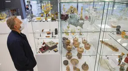 Orang-orang yang memakai masker mengunjungi pameran kesenian rakyat tradisional Rusia di Moskow, Rusia, 4 Oktober 2020. Lebih dari 1.000 karya seni tradisional Rusia buatan produsen kerajinan terkemuka dipamerkan di acara tersebut. (Xinhua/Alexander Zemlianichenko Jr)