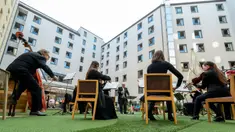 Para tamu Zeitgeist Hotel menikmati dari kamar mereka penampilan penyanyi Monika Medek dan Dagmar Dekanovsky serta orkestra Camerata Carnutum di Wina, Sabtu (30/5/2020). "Konser jendela" diadakan untuk merayakan pembukaan kembali hotel di Austria di tengah pandemi COVID-19. (JOE KLAMAR/AFP)