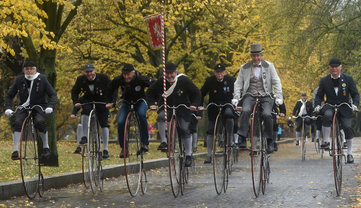 Para penggemar sepeda mengenakan kostum sejarah sambil mengendarai Penny Farthing atau dikenal sebagai sepeda roda tinggi selama kompetisi tradisonal 'One Mile Race' di Praha, Republik Ceko pada 3 November 2018. (Photo by Michal CIZEK / AFP)